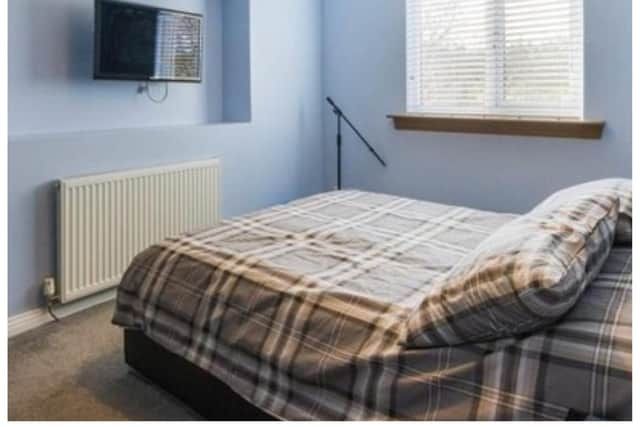 In the corner of Lewis Capaldi's old bedroom a microphone stand can be seen.