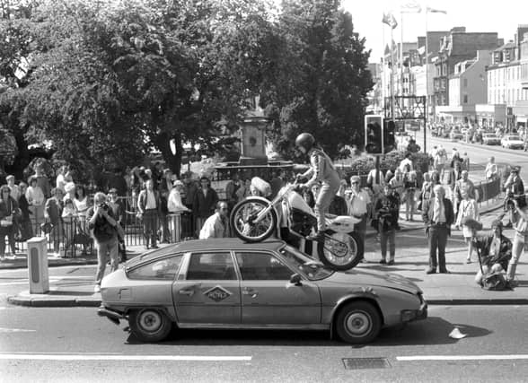 French circus Archoas can be seen here driving a motorbike over a car on Waverley Bridge as part of a publicity stunt for their Edinburgh Festival Fringe show. Year: 1989