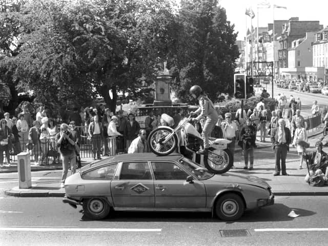 French circus Archoas can be seen here driving a motorbike over a car on Waverley Bridge as part of a publicity stunt for their Edinburgh Festival Fringe show. Year: 1989