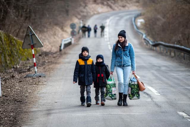 A woman with two children walk towards the border with Slovakia near the Ukrainian city of Welykyj Beresnyj following the Russian invasion (Picture: Peter Lazar/AFP via Getty Images)
