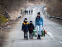 A woman with two children walk towards the border with Slovakia near the Ukrainian city of Welykyj Beresnyj following the Russian invasion (Picture: Peter Lazar/AFP via Getty Images)