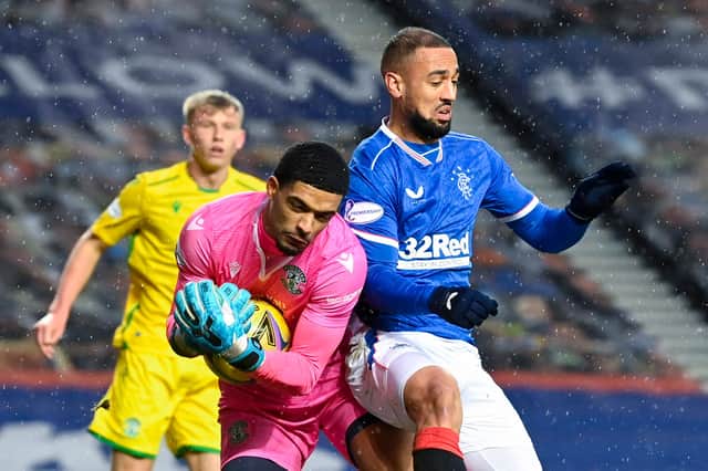 Hibs goalkeeper Dillon Barnes clutches the ball under pressure from Rangers striker Kemar Roofe