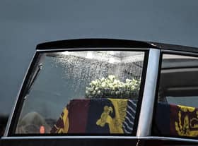 Raindrops run down the window of the Royal Hearse as it departs, carrying the coffin of Queen Elizabeth II