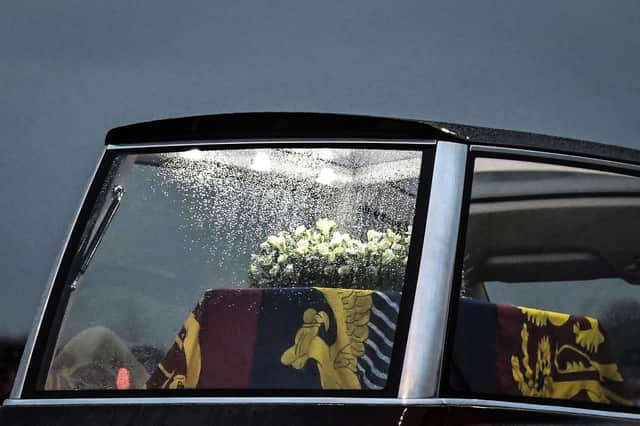 Raindrops run down the window of the Royal Hearse as it departs, carrying the coffin of Queen Elizabeth II