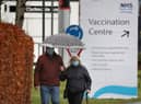 People walk passed a Vaccination Centre sign at the Royal Highland Show ground in Edinburgh, where lockdown measures introduced on January 5 for mainland Scotland remain in effect until at least the end of February. Picture date: Thursday February 4, 2021.