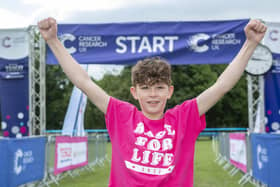 Leo Barker, an 11-year-old from Livingston who had a liver transplant during the pandemic after being diagnosed with cancer sounds the horn at the start of Pretty Muddy Kids at the the Meadow’s, Edinburgh. (Photo credit: Lesley Martin)