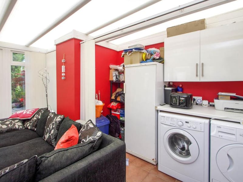 The spacious conservatory also features this handy utility area. It provides space for a washing machine, dryer, fridge freezer and work station.
