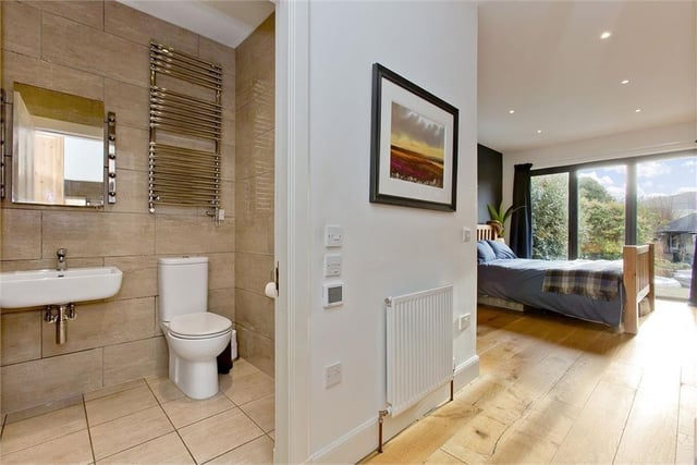The principal bedroom boasts a dressing area, a large built-in wardrobe, bi-folding doors, and an en-suite shower room.