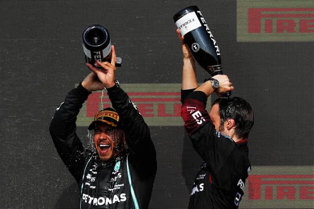 Lewis Hamilton, left, pours Champagne over his head on the podium after winning the Formula One Grand Prix at Silverstone (Picture: Adrian Dennis/AFP via Getty Images)