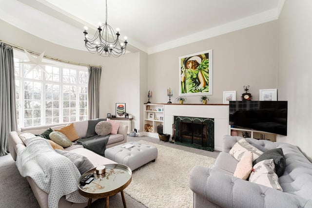 The impressive south-facing living room has a stunning curved bay window, high ceilings and an open fire with surround.