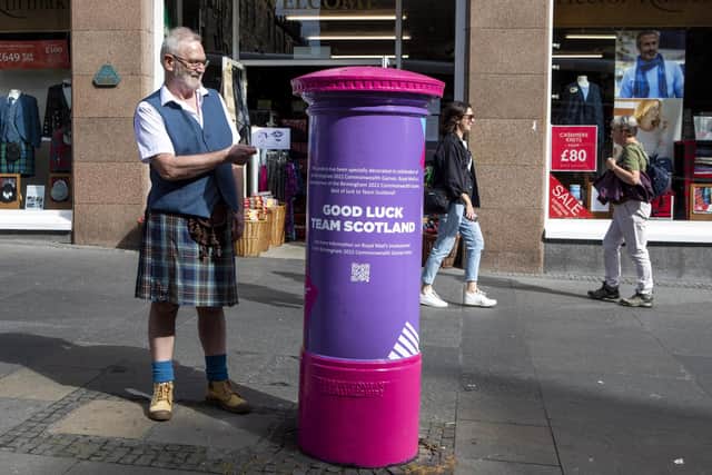 A kilted George Johnston with Royal Mail post box on Edinburgh's Royal Mile, celebrating the Commonwealth Games 2022 being held in Birmingham.