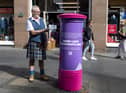 A kilted George Johnston with Royal Mail post box on Edinburgh's Royal Mile, celebrating the Commonwealth Games 2022 being held in Birmingham.
