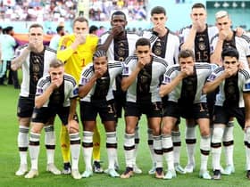 Germany players pose with their hands covering their mouths as they line up for the team photos prior to the World Cup Group E match against Japan at Khalifa International Stadium. Picture:  Alexander Hassenstein/Getty