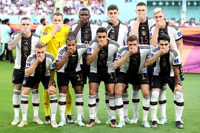 Germany players pose with their hands covering their mouths as they line up for the team photos prior to the World Cup Group E match against Japan at Khalifa International Stadium. Picture:  Alexander Hassenstein/Getty