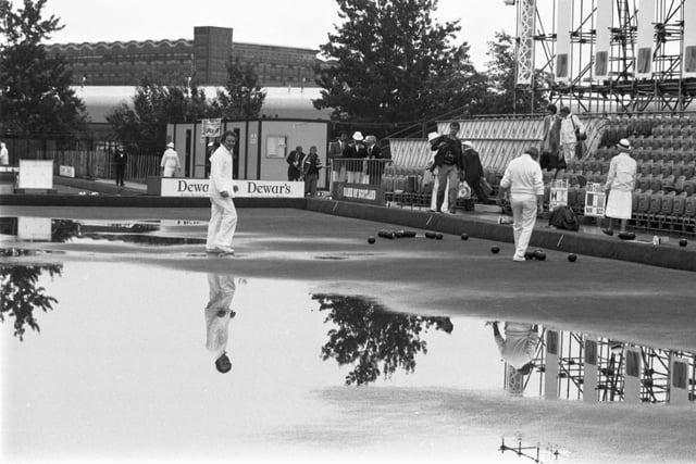 Rain doesn't stop play in the bowling events of the 1986 Commonwealth Games in Edinburgh. Despite the greens being flooded, play continued at Balgreen bowling club after heavy rain.