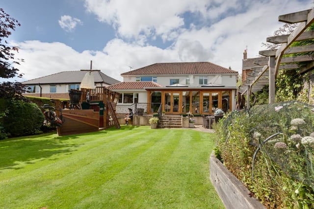 The property is set far back from the road within a plot that extends to approximately a third of an acre, with a generously sized rear garden with lawns, mature trees, shrub borders, two summerhouses and a pirate ship.