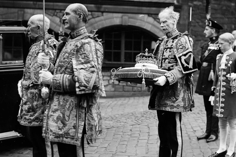 The Queen's regalia is presented at St Giles' Cathedral. The crown is carried by Sir Thomas Innes of Learney, Lord Lyon King of Arms; the sword by Lieut.-Colonel H A B Lawson, Rothesay Herald; the sceptre by Lieut.-Colonel J W Balfour Paul, Marchmont Herald.