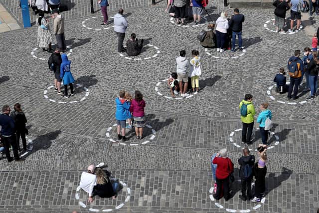 Visitors at Edinburgh Castle stand socially distanced in marked out circles as they watch the daily one o'clock gun ceremony.