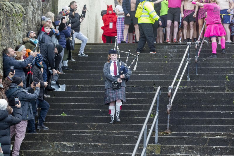 A young piper plays as participants at the Loony Dook enjoy some fun in the cold water at South Queensferry