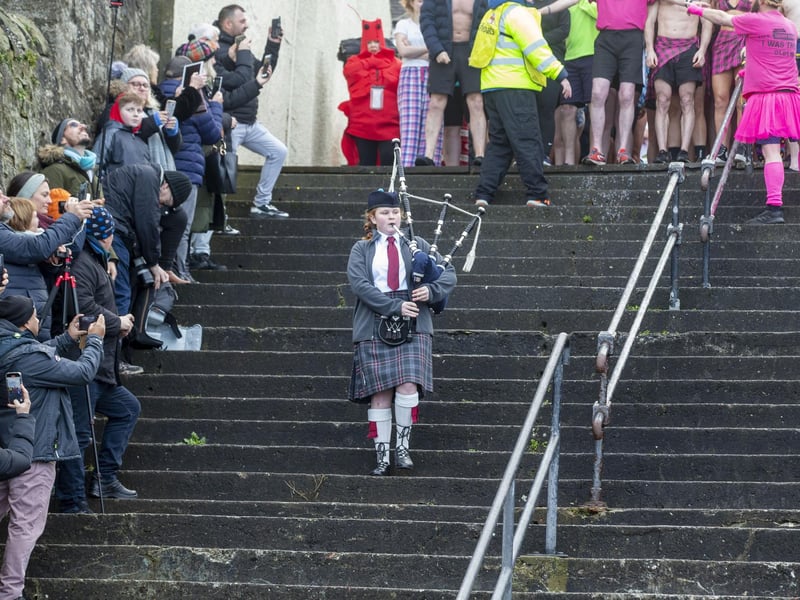 A young piper plays as participants at the Loony Dook enjoy some fun in the cold water at South Queensferry