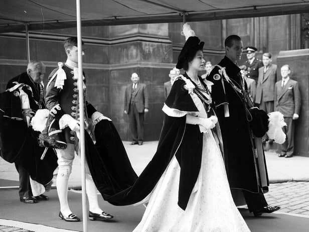 Queen Elizabeth II and the Duke of Edinburgh walk to Signet Library from St Giles' Cathedral after a service. The Queen is dressed in a robe of the Order of the Thistle