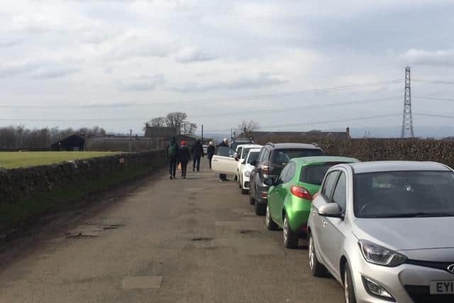 Dozens of cars parked along the road leading up to Harlaw Reservoir.