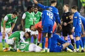Hibs' Martin Boyle goes down injured after collision with Rangers' John Souttar.
