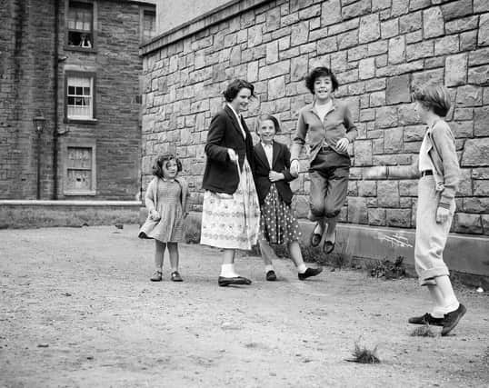 Girls playing skipping ropes in Lapicide Place (August 1957).