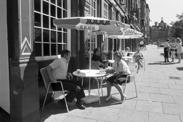 People drinking at tables on the pavement outside the White Hart Inn in Edinburgh's Grassmarket, June 1988.