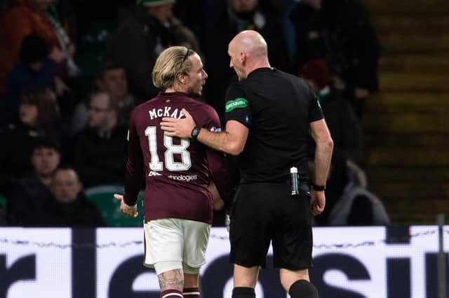 Referee Bobby Madden with Hearts winger Barrie McKay after he is hit with objects from the Celtic support last Thursday.