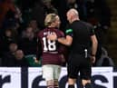 Referee Bobby Madden with Hearts winger Barrie McKay after he is hit with objects from the Celtic support last Thursday.