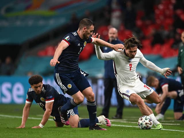 LONDON, ENGLAND - JUNE 18: Jack Grealish of England runs with the ball whilst under pressure from Stephen O'Donnell and Che Adams of Scotland during the UEFA Euro 2020 Championship Group D match between England and Scotland at Wembley Stadium on June 18, 2021 in London, England. (Photo by Andy Rain - Pool/Getty Images)