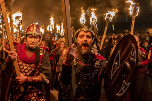 Vikings from the Shetland South Mainland Up Helly Aa Jarl Squad lead the torchlight procession.