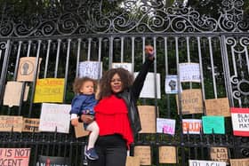 Mother stands strong with her daughter in front of hundreds of anti-racist placards and signs used during today's Black Lives Matter protests
