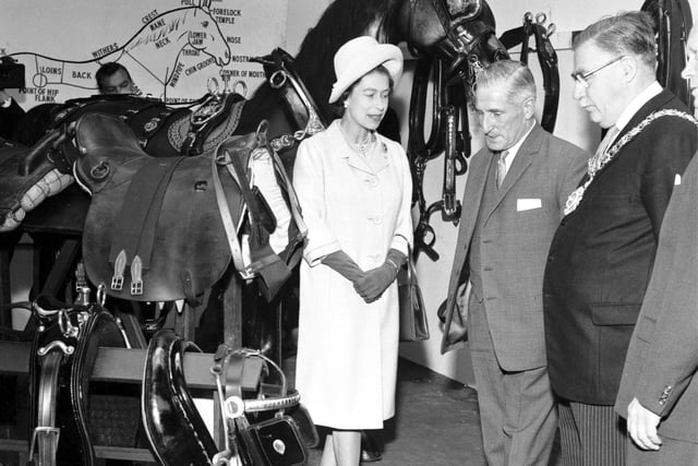Queen Elizabeth II inspecting bridles, sadles and halters during a visit to St Cuthbert's Transport Department in Edinburgh in June 1966.