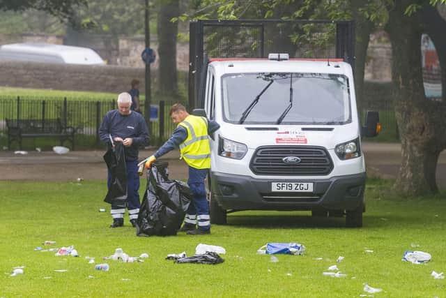 Council employees clear the waste left in the Meadows after a large gathering on the hottest day of the year
