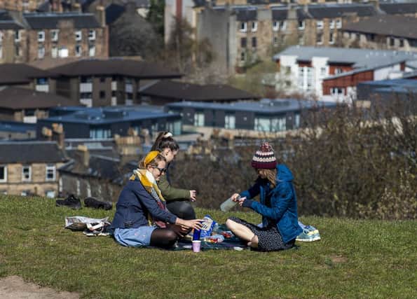 Three people enjoy a picnic on Calton Hill (Picture: Lisa Ferguson)