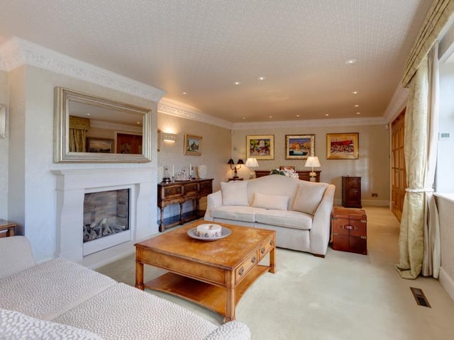 The cosy lounge is generous in size and features a log effect gas fire at its heart, with a limestone mantel, and front and side facing double glazed windows with electric curtain rails.
