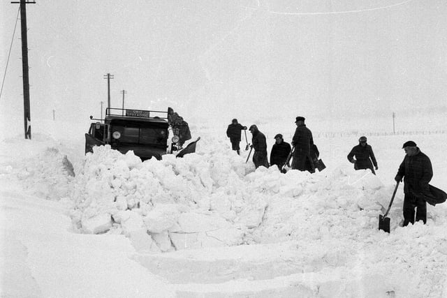 A snow-plough forces a passage through deep drifts on Peebles Road.