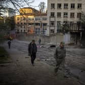 People walk past the site of an explosion in Kyiv, Ukraine on Friday, April 29, 2022. Russia struck the Ukrainian capital of Kyiv shortly after a meeting between President Volodymyr Zelenskyy and U.N. Secretary-General António Guterres on Thursday evening. (AP Photo/Emilio Morenatti)