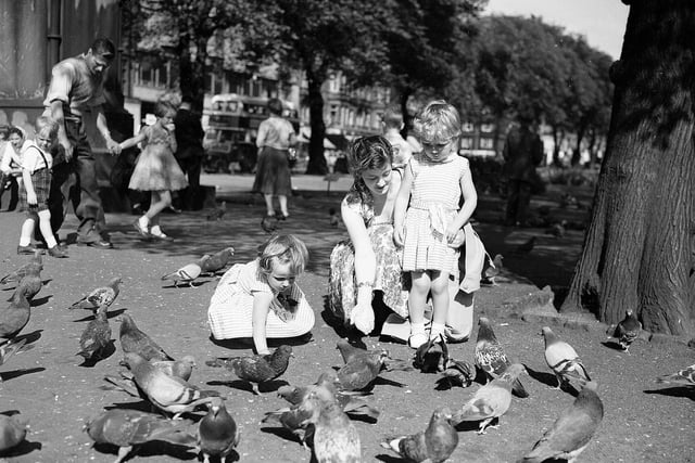 A mother and her daughters feeding the pigeons in Princes Street Gardens in the summer of 1959.