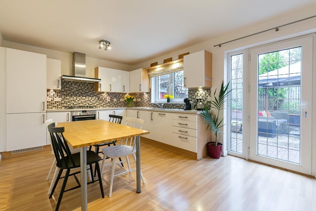 With dual access from the hall and dining room, the stylish kitchen is fitted with modern units and worktops, a tiled surround, and a sink with drainer; and features ample space for a further dining area and a patio door accessing the southeasterly facing rear garden. Appliances include an integrated oven, a gas hob with an extractor hood above, a dishwasher and a fridge/freezer.