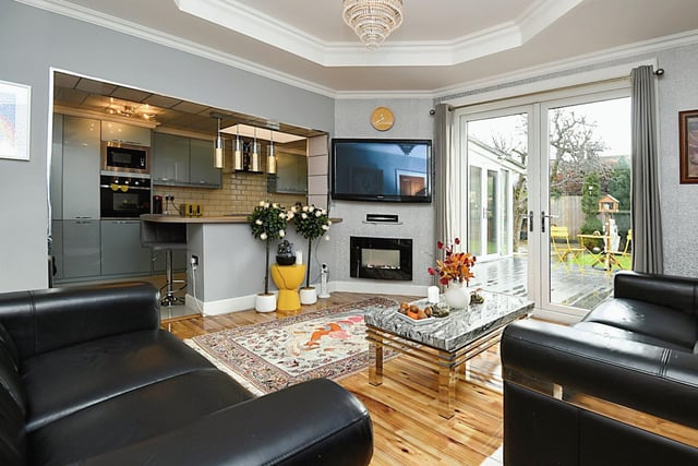The spacious living room features a living flame gas fire and French doors leading out to the garden.