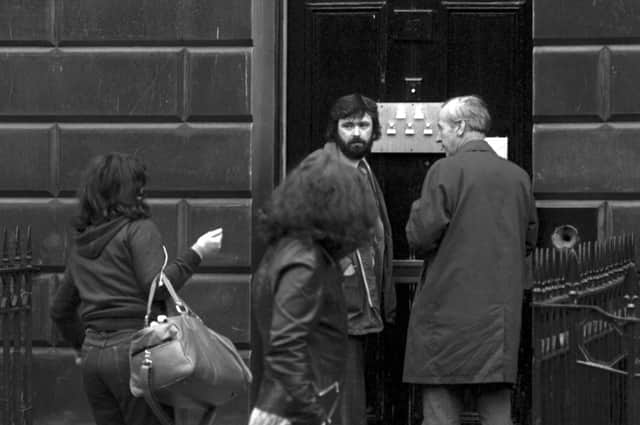 Council officials pin an inspection notice to the door of Dora Noyce's brothel at 17 Danube Street, Edinburgh, in October 1977 as a couple of women arrive at the flat  Pic by: Jack Crombie