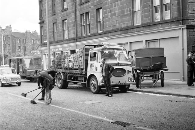 Clearing up after a milk horse bolts and injures itself outside the Station Bar in Gorgie Road in June 1966.