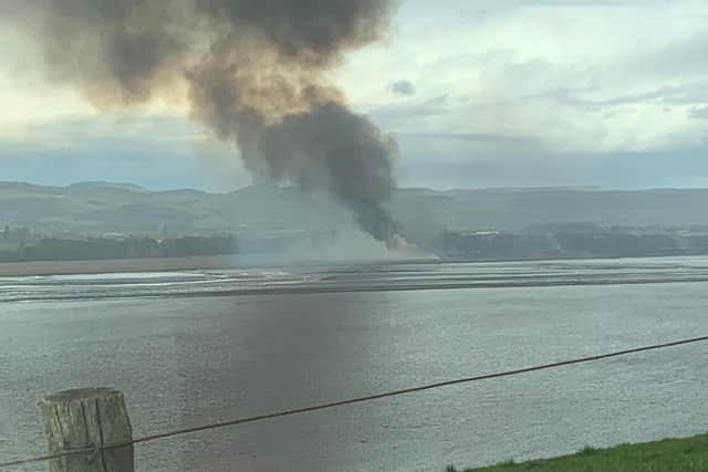 Thick black smoke billows up from the reed beds near Errol Airfield, Perthshire.