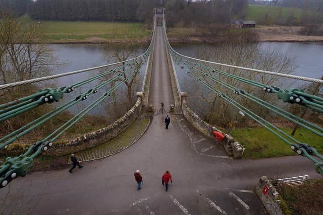 Members of the public cross the Union Bridge on the River Tweed
