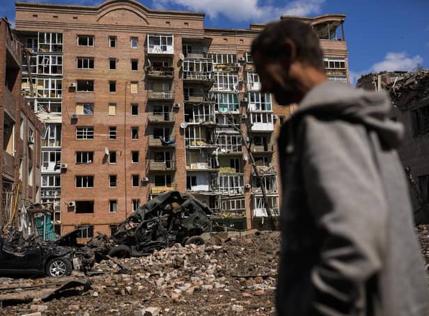 A man walks next to heavily damaged buildings and destroyed cars following Russian attacks in Bakhmut, Donetsk region, eastern Ukraine, Tuesday, May 24, 2022. The region, along with neighbouring Luhansk, is part of the Donbas, where Russian forces have focused their offensive. (AP Photo/Francisco Seco)