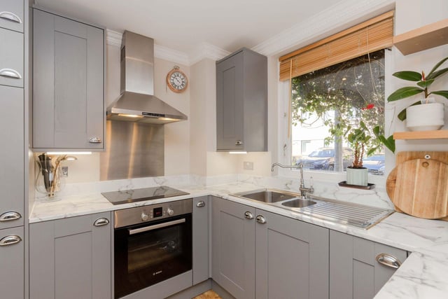 The open plan kitchen has shaker-style units, a breakfast bar and integrated appliances.