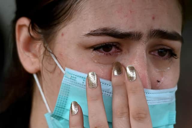 An Afghan woman living in India reacts outside the embassy of the United States of America in New Delhi (Photo by Money Sharma / AFP) (Photo by MONEY SHARMA/AFP via Getty Images)